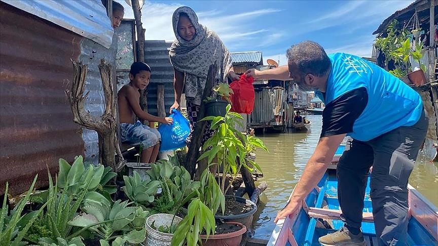 Residents of a floating river village in the Philippines receive Ramadan aid from a Turkish agency
